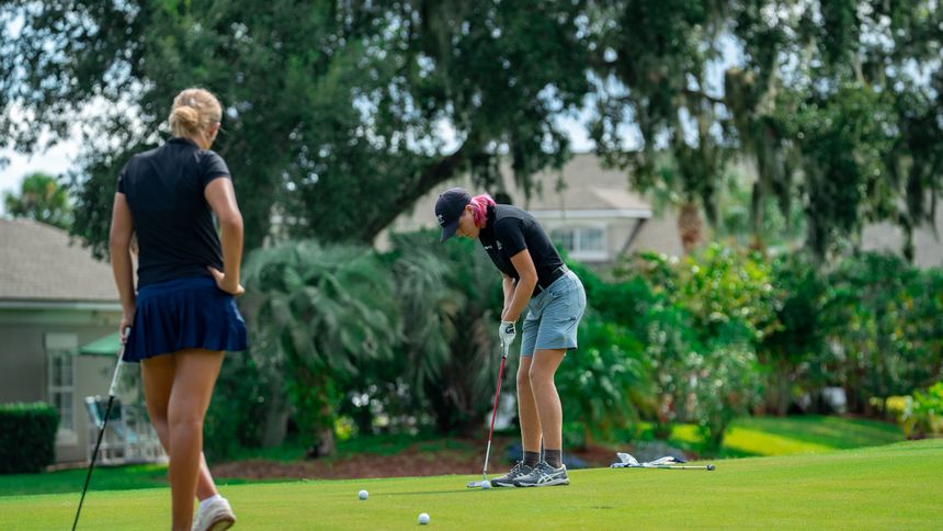 Two DME golfers working through a putting session on the practice green.
