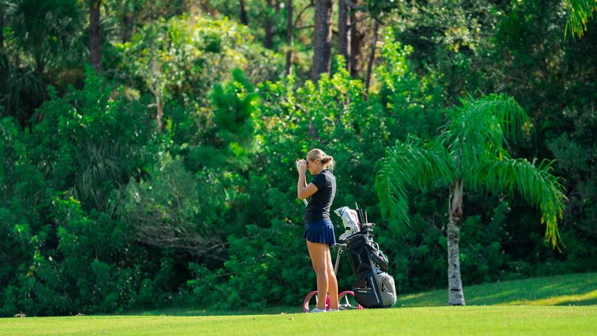 A DME golfer preparing at their bag before playing a shot.