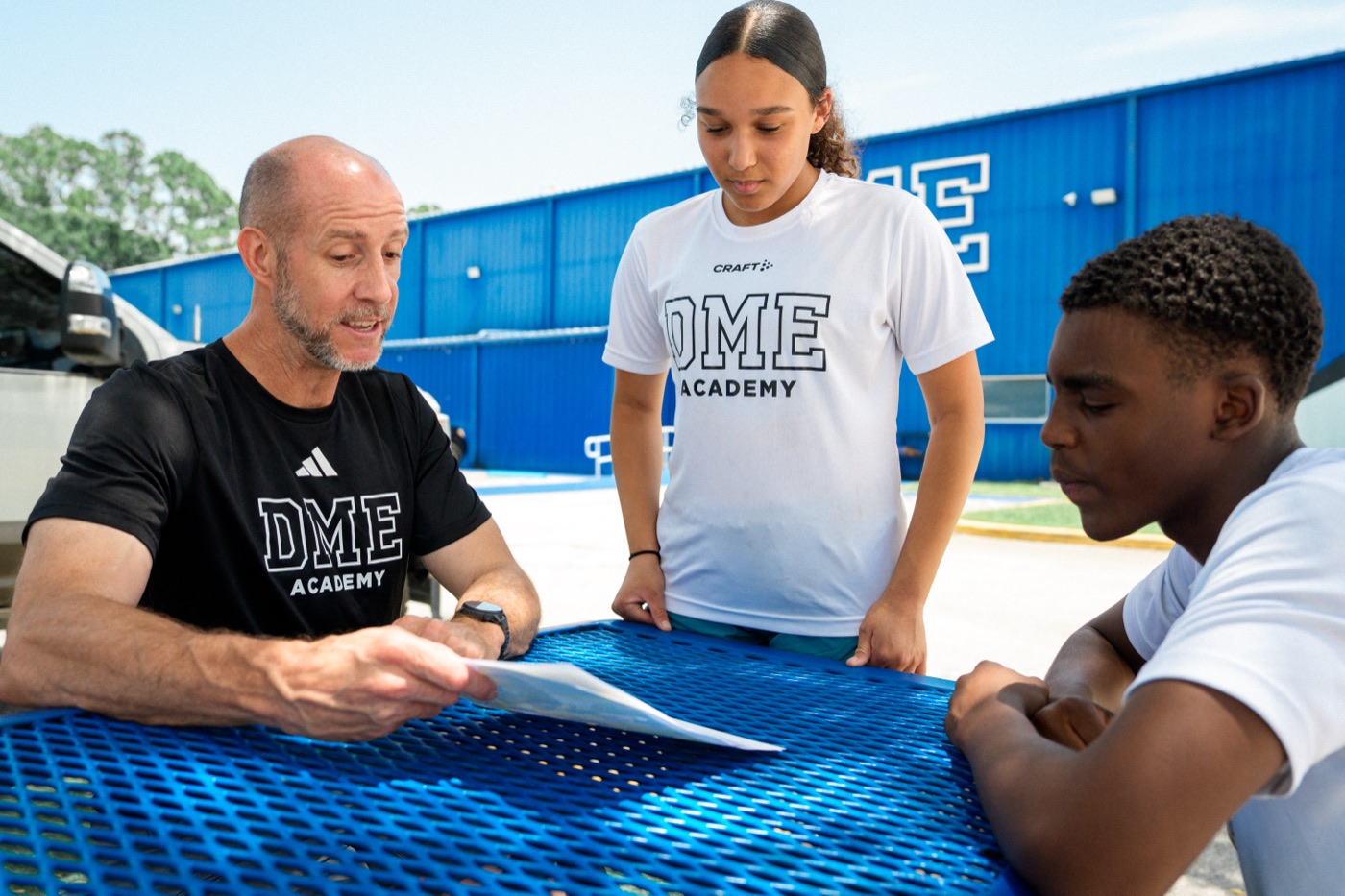 Donovan Gibson meets with two DME Academy student-athletes on campus