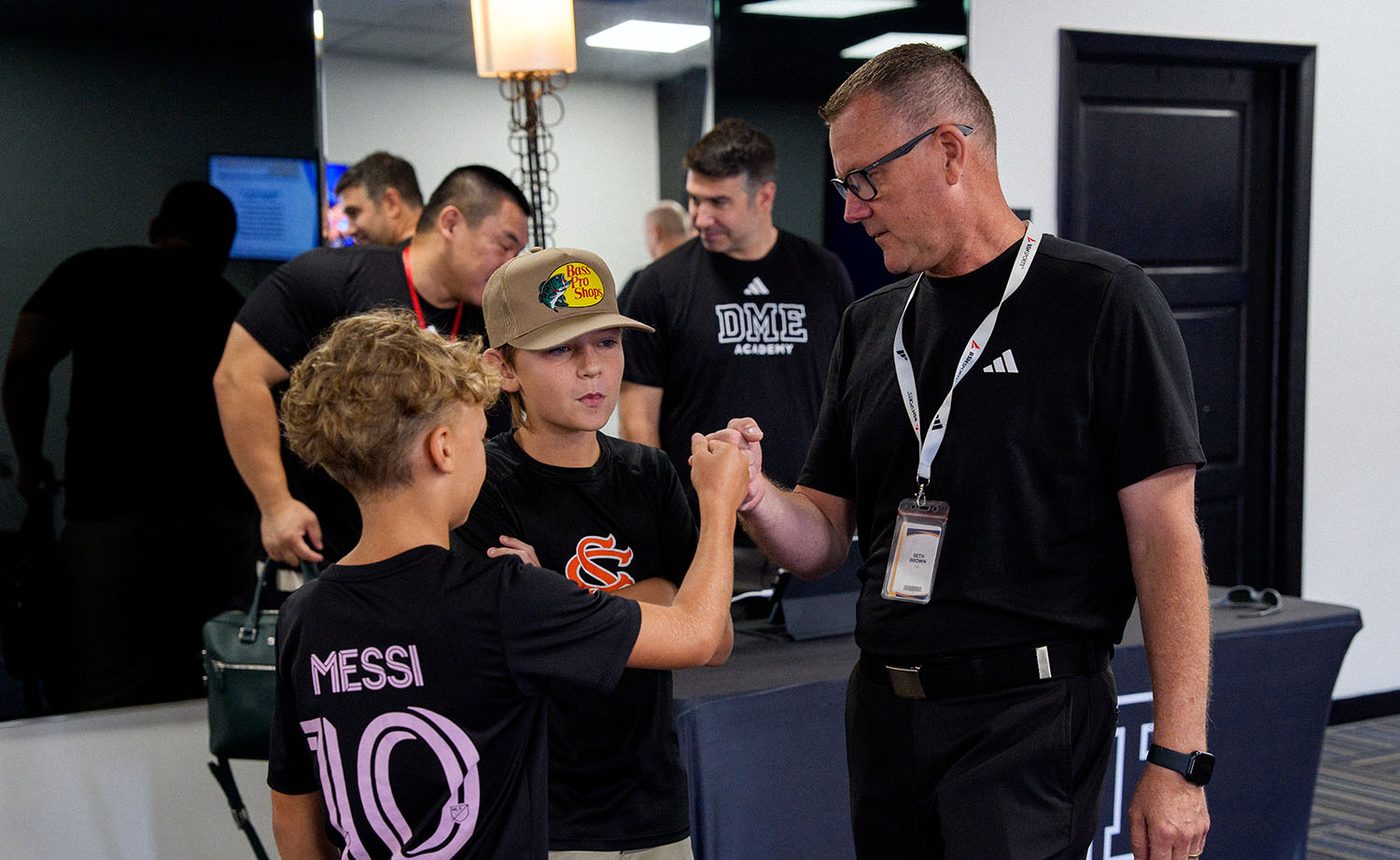 DME Academy CEO Seth Brown greets two young prospective student-athletes at Prospect Day check-in